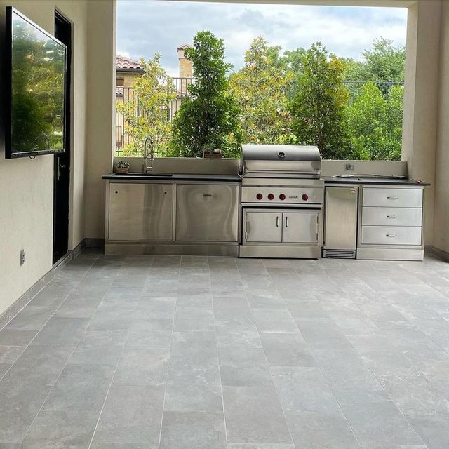 Covered outdoor patio and kitchen with large gray porcelain tile