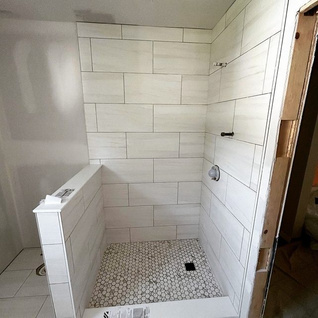 White rectangular wall tile shower with a hexagon mosaic shower floor